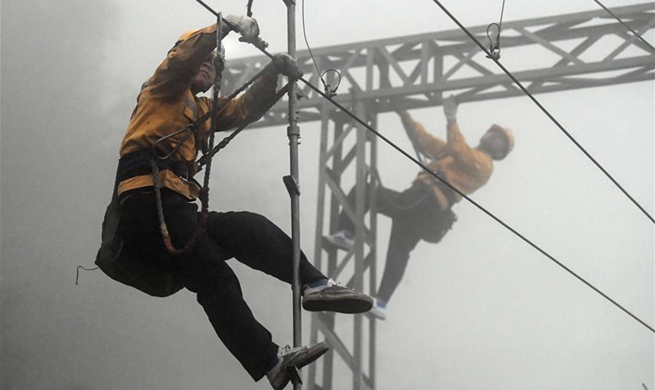 Workers overhaul overhead line system along railway to ensure traffic safety